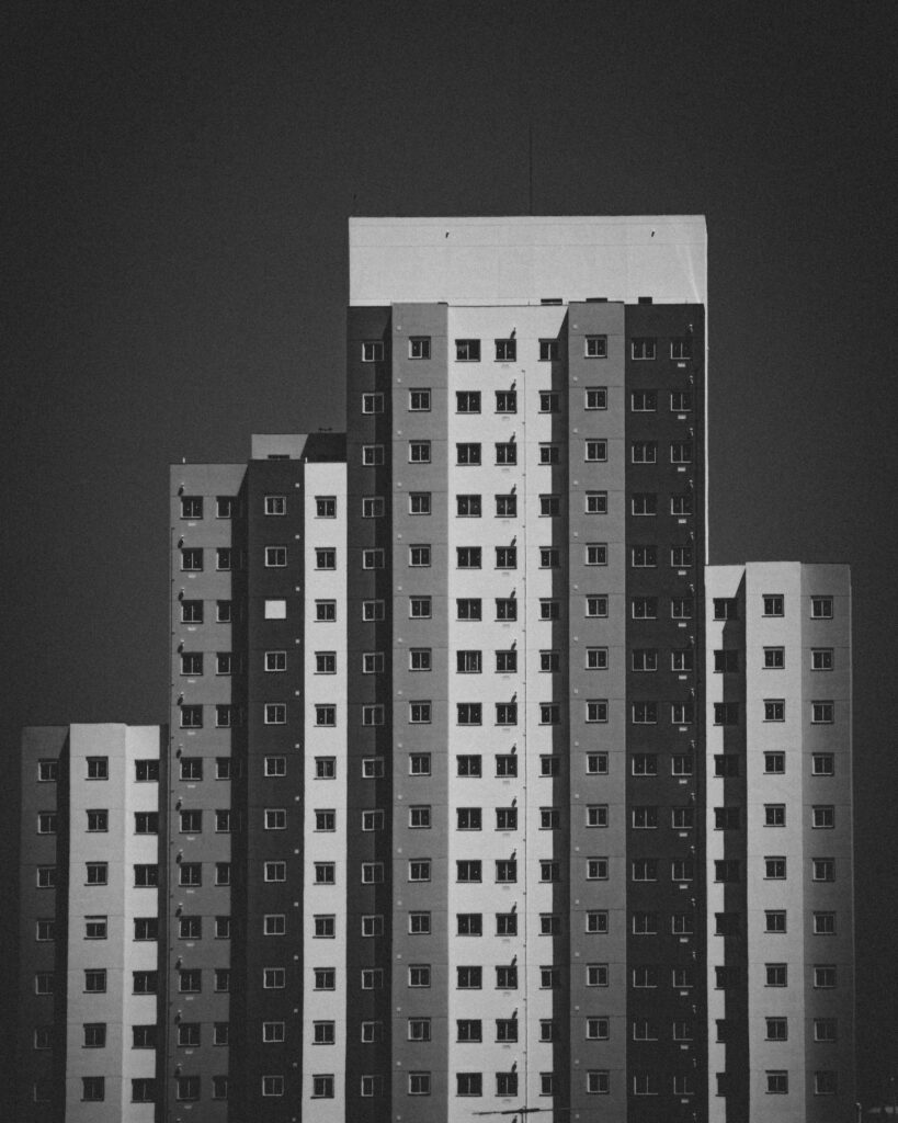 A striking black and white photo of a modern high-rise apartment building exterior.